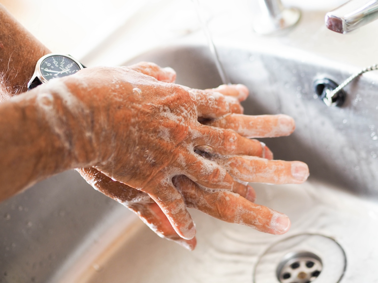 person washing hands - turn off the tap while washing hands - sustainable habits for 2024